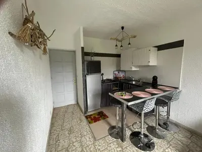 a small kitchen with a table and a refrigerator at Appartement avec balcon à Marignana, 30 m², 4 pers. in Marignana