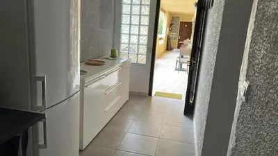 a kitchen with a white refrigerator and a hallway at Appartement convivial à Marignana, proche de la nature in Marignana