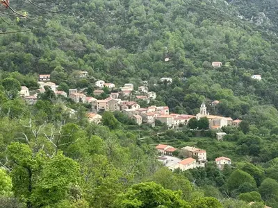 a small town on a hill in the mountains at Appartement convivial à Marignana, proche de la nature in Marignana