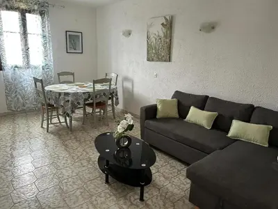 a living room with a couch and a table at Appartement convivial à Marignana, proche de la nature in Marignana