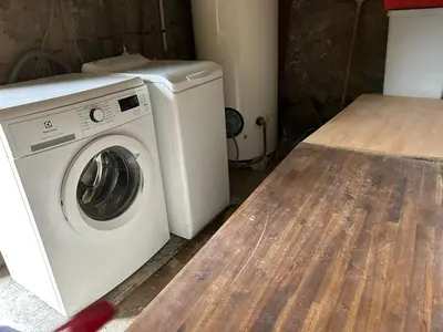 a white washing machine sitting in a laundry room at Appartement convivial à Marignana, proche de la nature in Marignana
