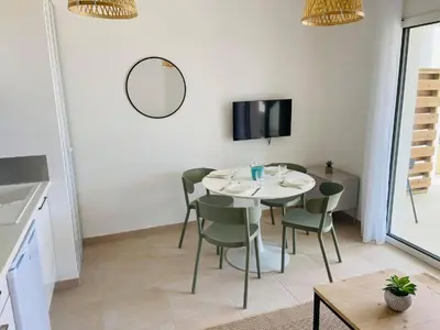 a dining room with a table and chairs and a tv at T3 bord de mer en Corse N130 in Linguizzetta