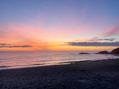 a sunset on a beach with the ocean at T3 bord de mer en Corse N130 in Linguizzetta