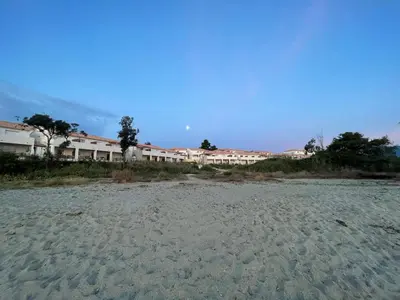 a sandy beach with a building in the background at Appartement T2 bord de mer N165 in Linguizzetta