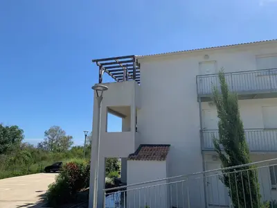 a white apartment building with a spiral staircase at Appartement T2 bord de mer N165 in Linguizzetta