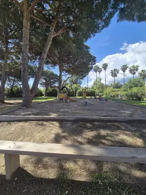 a bench in a park with a playground at hjpp in Poggio-Mezzana