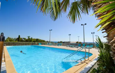 a person swimming in a large swimming pool at Appartement Residence Piscine in Prunete