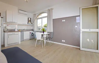 a kitchen with a table and chairs in a room at Appartement Residence Piscine in Prunete