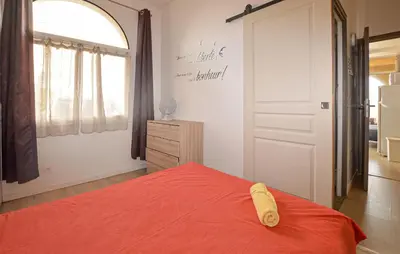 a bedroom with a bed with a red bedspread at Appartement Residence Piscine in Prunete
