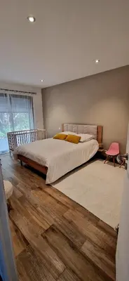 a bedroom with a large bed with a wooden floor at Villa moderne avec piscine 4 étoiles in Sotta