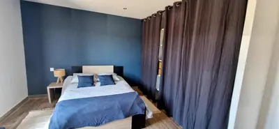 a bedroom with blue walls and a bed with blue pillows at Villa moderne avec piscine 4 étoiles in Sotta
