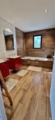 a bathroom with wooden floors and a sink and a tub at Villa moderne avec piscine 4 étoiles in Sotta