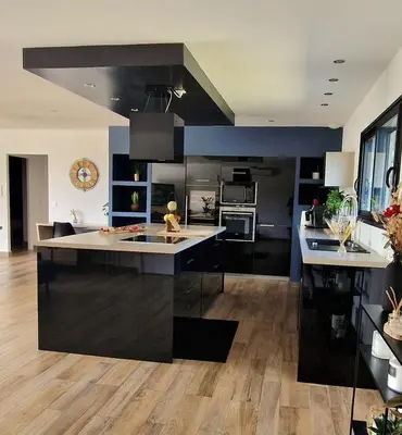 a kitchen with black cabinets and a large island at Villa moderne avec piscine 4 étoiles in Sotta