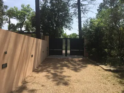 a gate in a fence with trees in the background at Résidence Anitrella in Porto-Vecchio