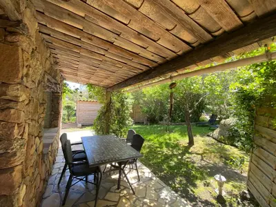 a patio with a table and chairs under a wooden ceiling at Résidence Anitrella in Porto-Vecchio