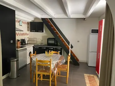 a kitchen with a table and chairs in a kitchen at Résidence Anitrella in Porto-Vecchio