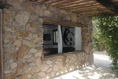 a stone house with a window in a stone wall at Résidence Anitrella in Porto-Vecchio