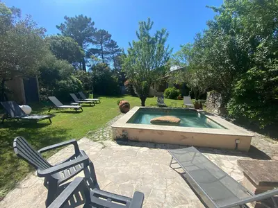a backyard with a pool with chairs and a table at Résidence Anitrella in Porto-Vecchio