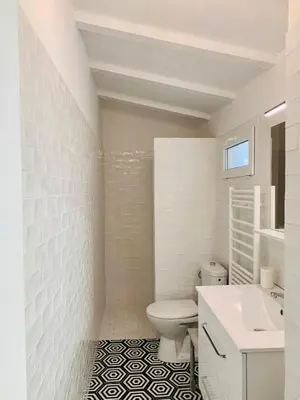 a white bathroom with a toilet and a sink at Superb sea view villa with pool and big garden in Pietrosella