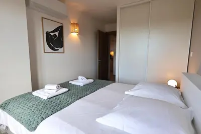 a bedroom with a white bed with towels on it at L'Envol - T3 vue mer avec piscine et plage privée in Pianottoli-Caldarello
