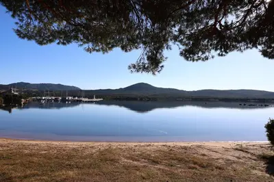 a view of a lake with a mountain in the background at L'Envol - T3 vue mer avec piscine et plage privée in Pianottoli-Caldarello