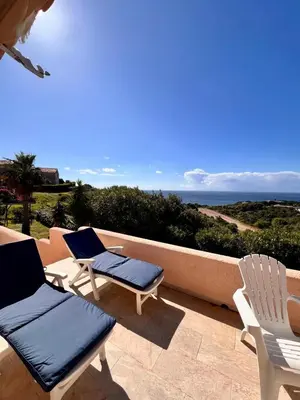 two chairs and chairs on a patio with the ocean at Logement A Nepita splendide vue mer avec piscine in Porto-Vecchio