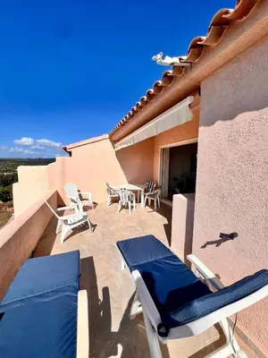 a patio with chairs and tables on a building at Logement A Nepita splendide vue mer avec piscine in Porto-Vecchio