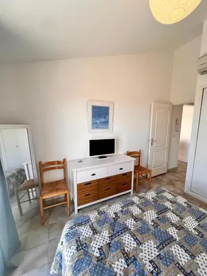 a bedroom with a bed and a tv on a dresser at Logement A Nepita splendide vue mer avec piscine in Porto-Vecchio