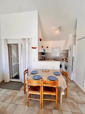 a kitchen and dining room with a table and chairs at Logement A Nepita splendide vue mer avec piscine in Porto-Vecchio
