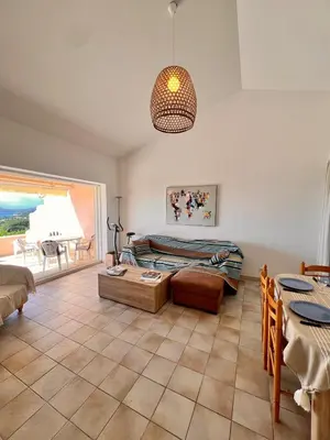 a living room with a bed and a table at Logement A Nepita splendide vue mer avec piscine in Porto-Vecchio