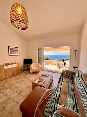 a living room with a couch and a view of the ocean at Logement A Nepita splendide vue mer avec piscine in Porto-Vecchio