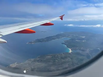 a view of the wing of an airplane flying over the ocean at VILLA HORUS - Bergerie 1chambre - piscine privée in San-Gavino-di-Carbini