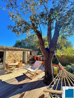 a patio with a tree and a table and chairs at VILLA HORUS - Bergerie 1chambre - piscine privée in San-Gavino-di-Carbini