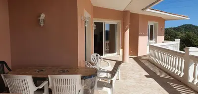 a patio with a table and chairs on a balcony at Villa PIETRAROSSA in Lecci