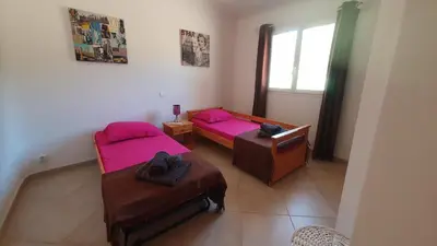 a room with two beds and a table and a window at Villa PIETRAROSSA in Lecci