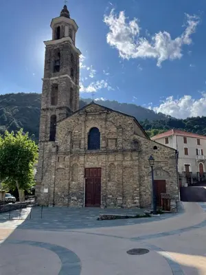 an old stone church with a tower on a street at Traversa in Vezzani