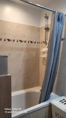 a bathroom with a bath tub with a shower curtain at appartement bords de Mer in Santa-Lucia-di-Moriani