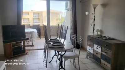 a room with a table and chairs and a window at appartement bords de Mer in Santa-Lucia-di-Moriani