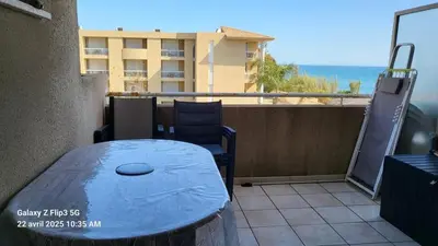 a table and chairs on the balcony of a building at appartement bords de Mer in Santa-Lucia-di-Moriani