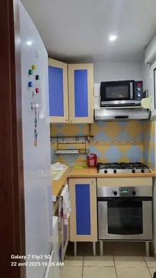 a kitchen with a refrigerator and a microwave at appartement bords de Mer in Santa-Lucia-di-Moriani