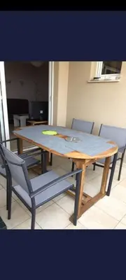 a wooden table with chairs around it in a room at appartement bords de Mer in Santa-Lucia-di-Moriani