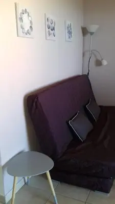 a couch in a room with a table and a lamp at appartement bords de Mer in Santa-Lucia-di-Moriani