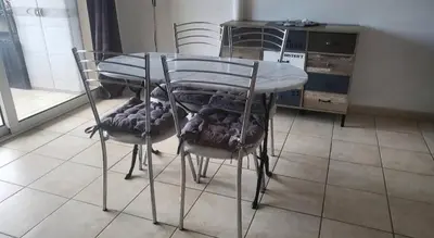 a glass table and two chairs in a kitchen at appartement bords de Mer in Santa-Lucia-di-Moriani