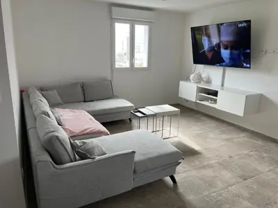 a living room with a couch and a flat screen tv at Chez lili in Ghisonaccia