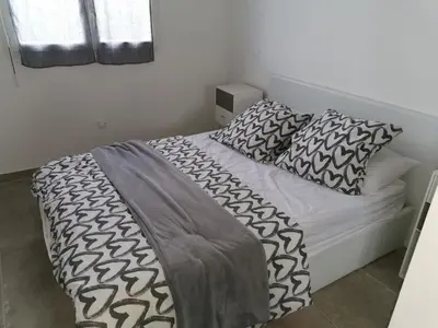 a bed with black and white sheets and pillows at Chez lili in Ghisonaccia