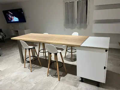 a wooden table with four chairs and a tv at Chez lili in Ghisonaccia