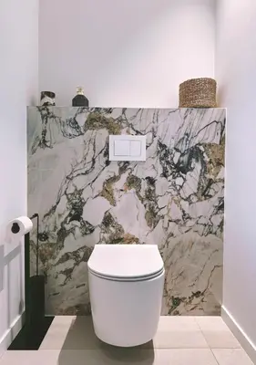 a white toilet in a bathroom with a marble wall at Villa Anjo in Zonza