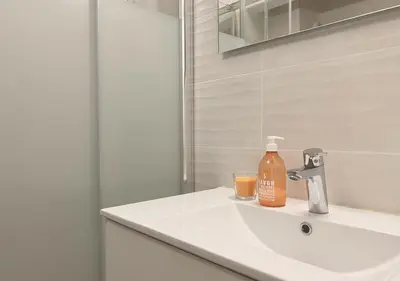 a bathroom sink with a bottle of soap on it at Studio Porto Vecchio centre in Porto-Vecchio