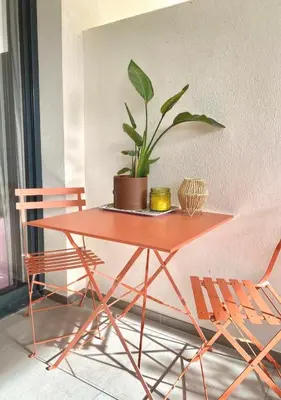 a table with a potted plant on it next to a chair at Studio Porto Vecchio centre in Porto-Vecchio