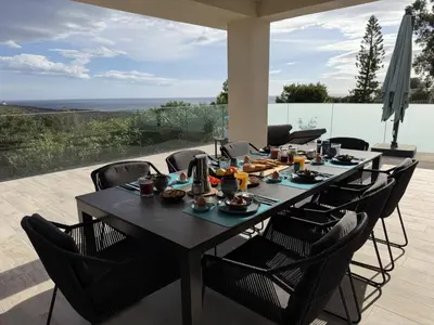 a kitchen with a black counter and a dining room at Casa Tre Fari in Bocca del Oro